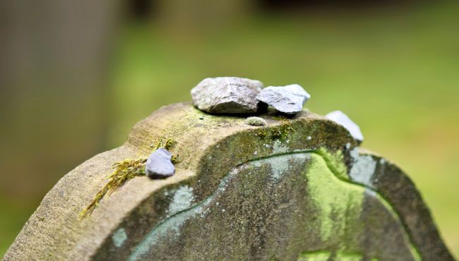 Stones sit on top of a Jewish headstone