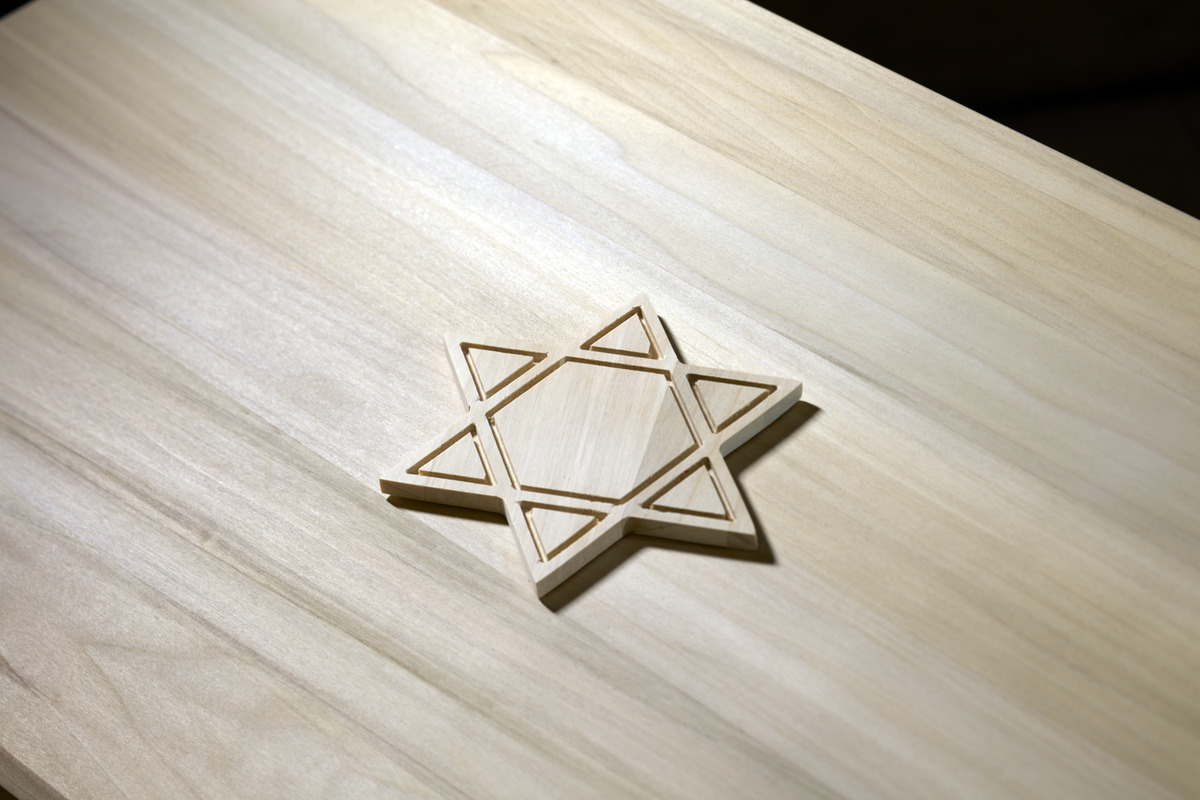 Granite headstone with stones left from visitors engraved with star of David